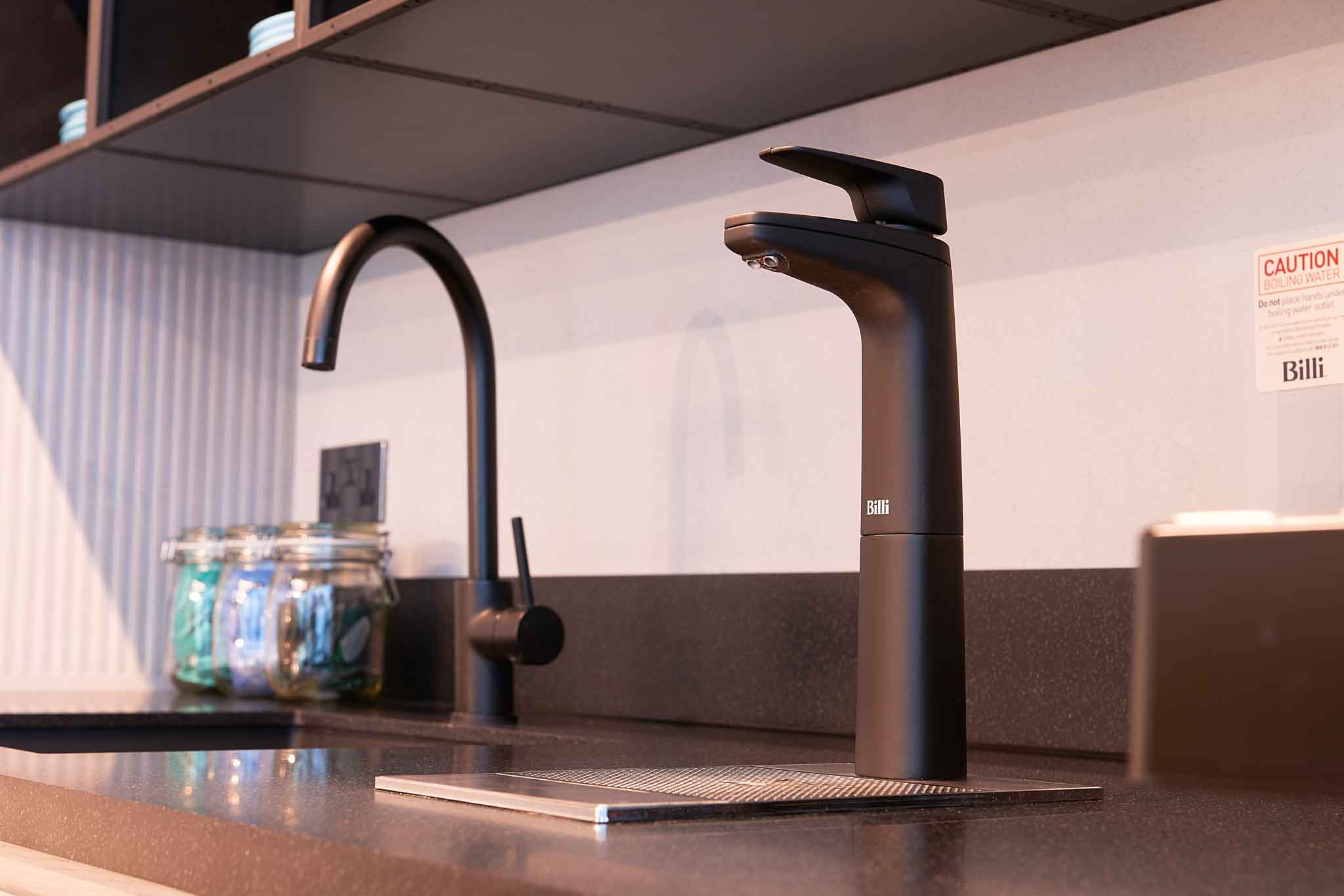 A matte black boiling water tap in a workplace kitchen