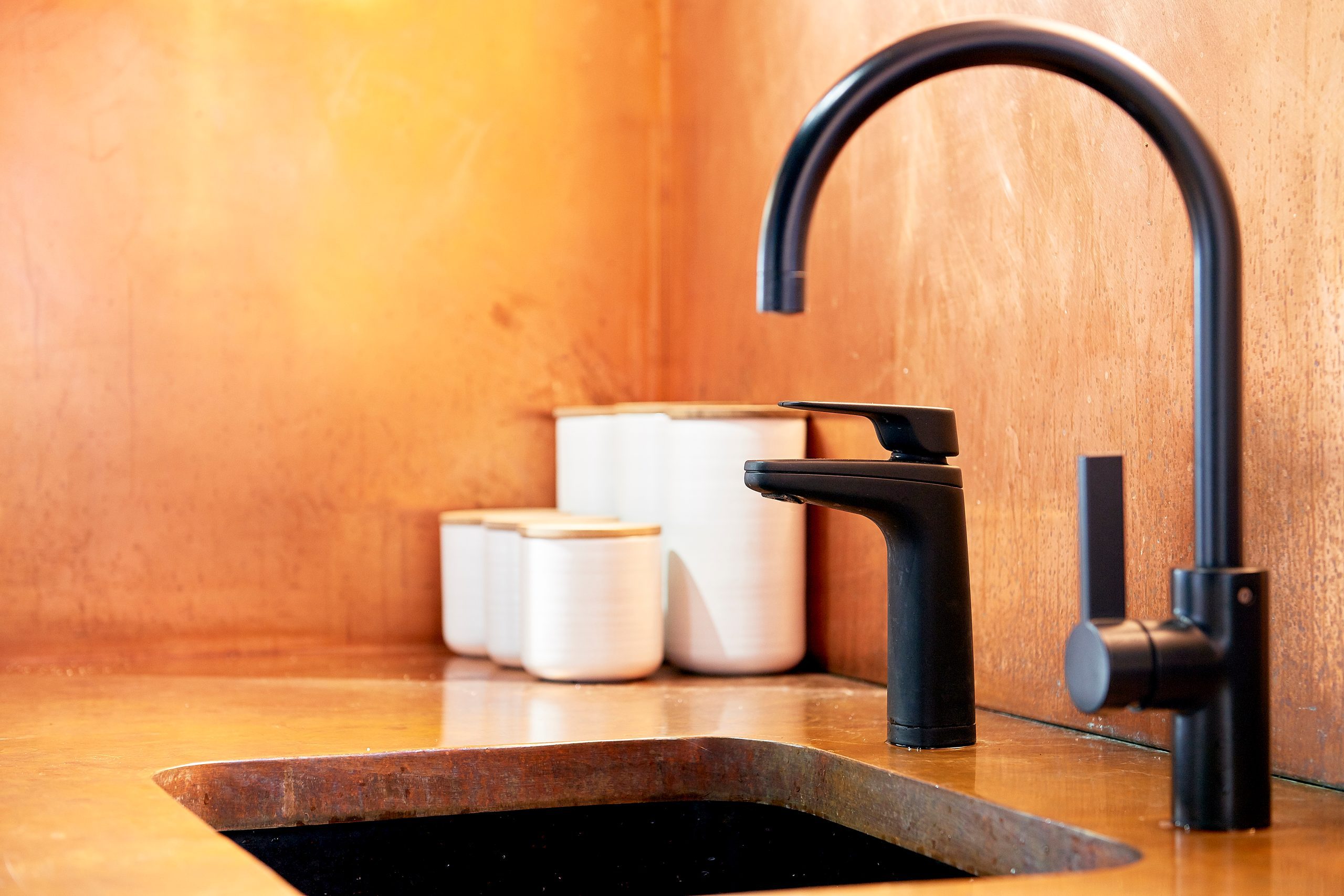 Matte black Billi XL dispenser and mixer tap against a copper splashback